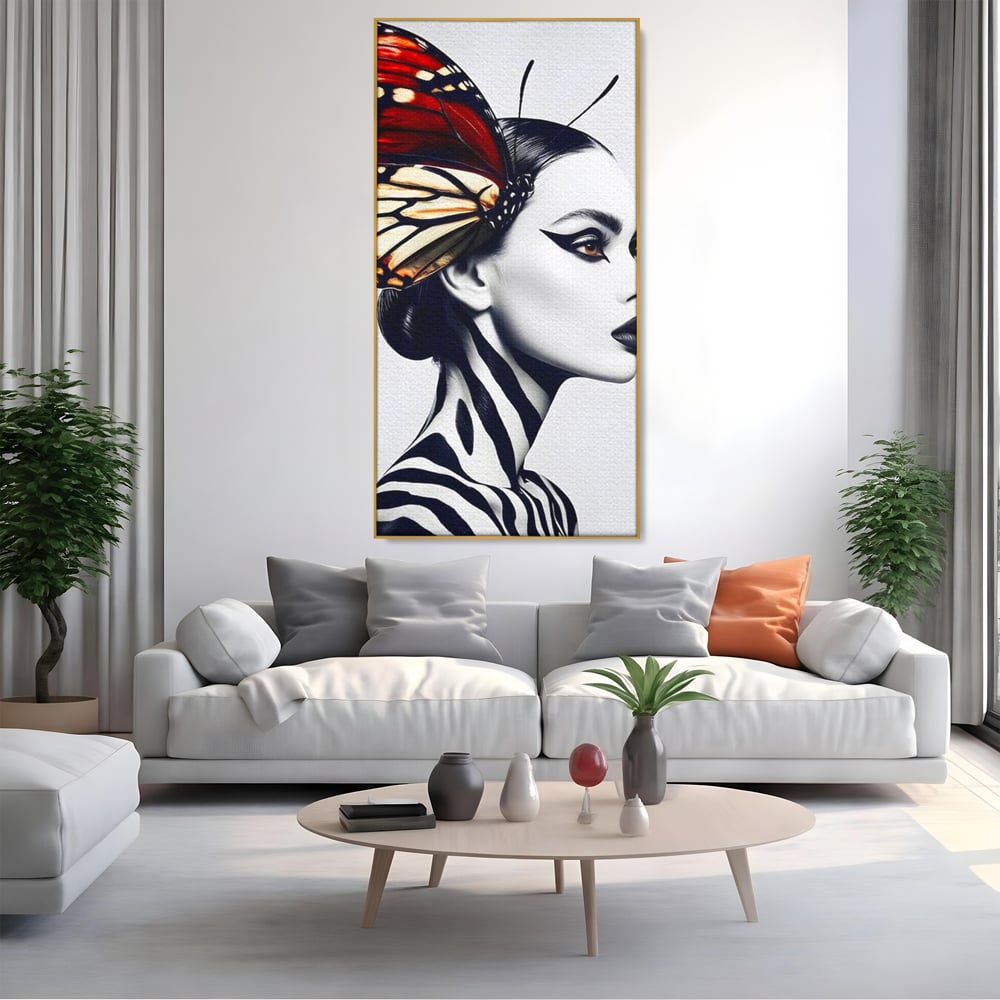 Tablou canvas cu tablou canvas cu femeie si aripa de fluture, in rama de aluminiu auriu, pe perete intr-un living